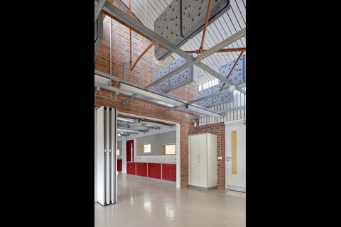 acoustic soundboards hang from the ceiling of one of the classrooms. Suspended ceilings were rejected in order to have as much of the building’s technical and constructional elements on display  as possible